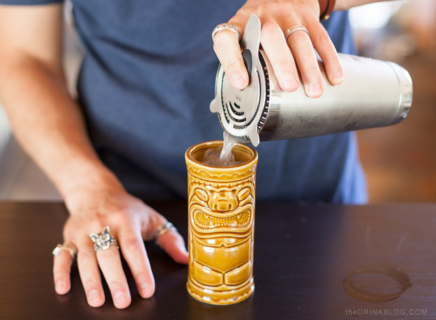 pour cocktail into tiki mug