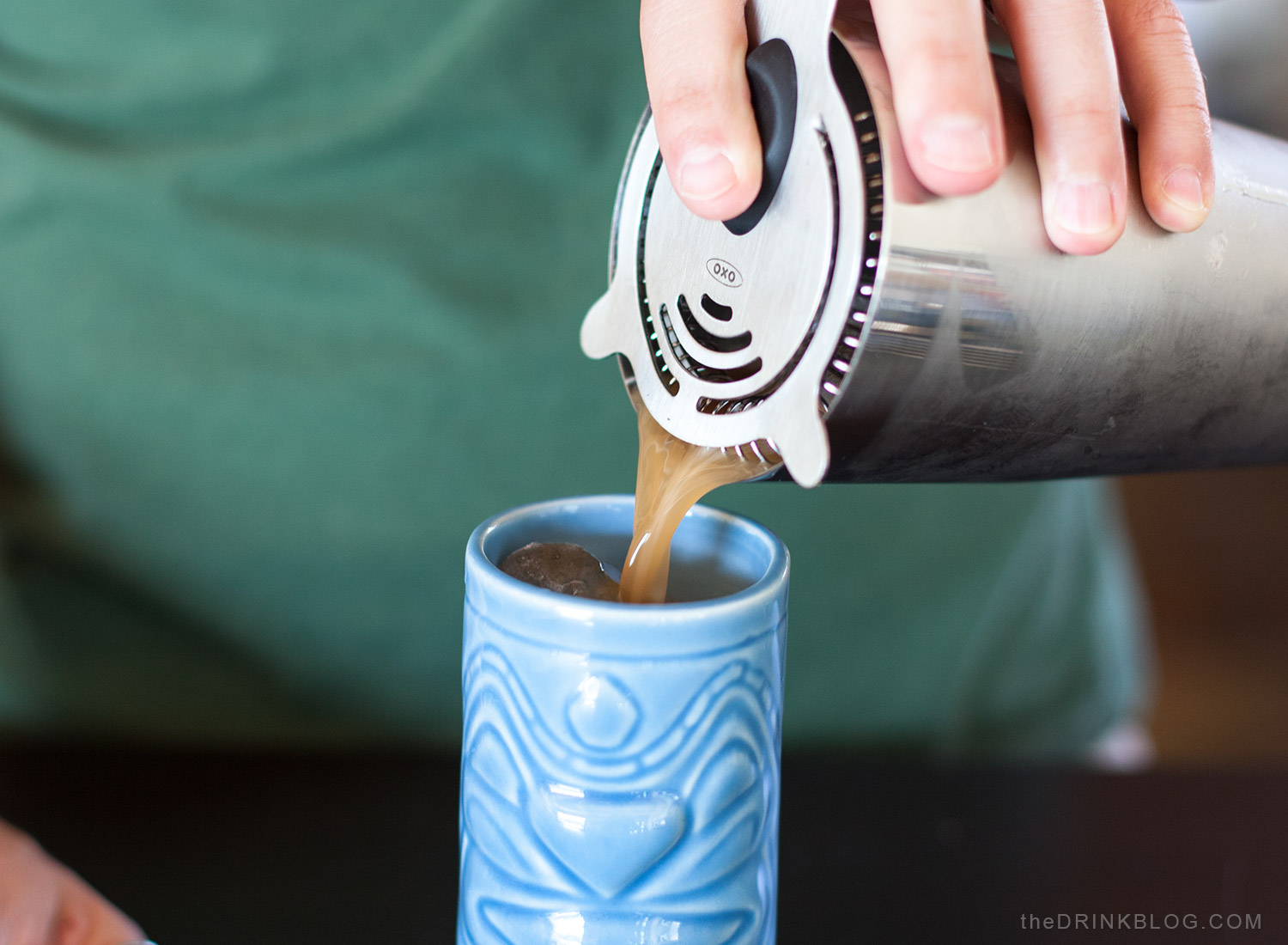 pour cocktail into tiki mug